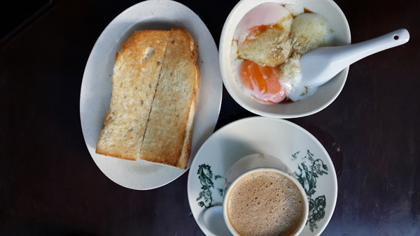 typical 1 Malaysia breakfast with toast, half boiled eggs, coffee - food shot